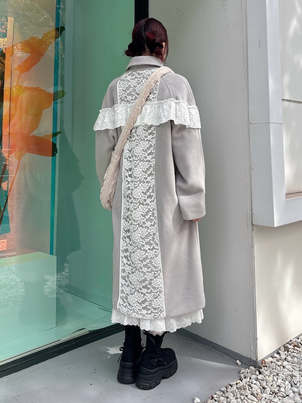 グレー系のチェスターコート、ベージュ系のショルダーバッグ、ホワイト系のワンピースを着用したレディースの秋コーディネートの2枚目の写真