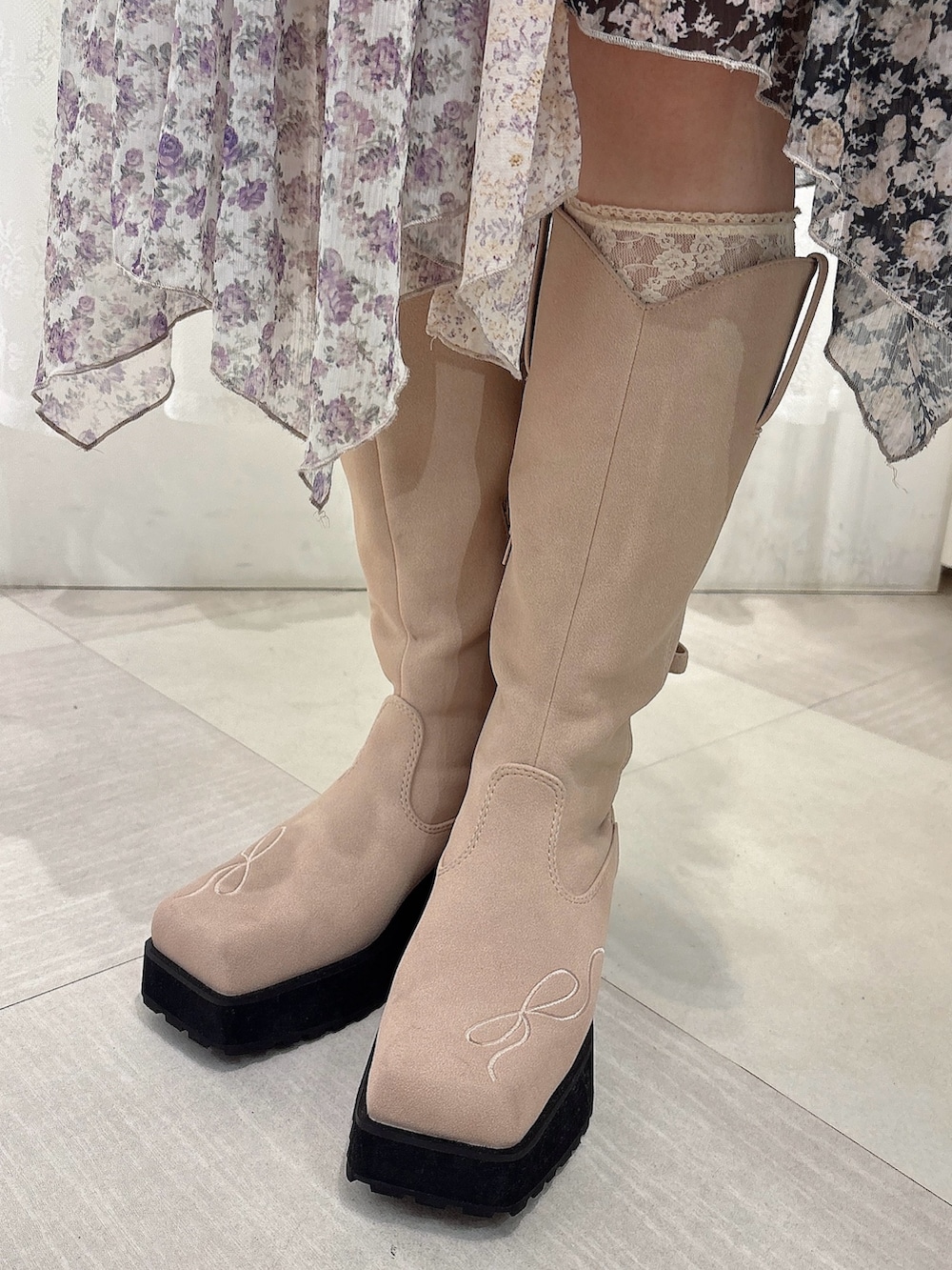 グレー系のニット/セーター、ブラック系のスカート、ピンク系のブーツを着用したレディースの秋コーディネートの6枚目の写真