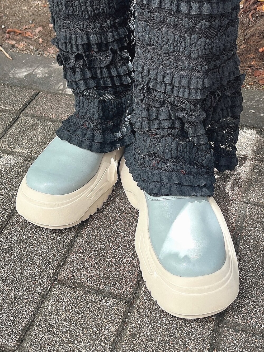 ブラック系のワンピース、ブラック系のスウェットパンツ、ブルー系のスニーカーを着用したレディースの秋コーディネートの3枚目の写真