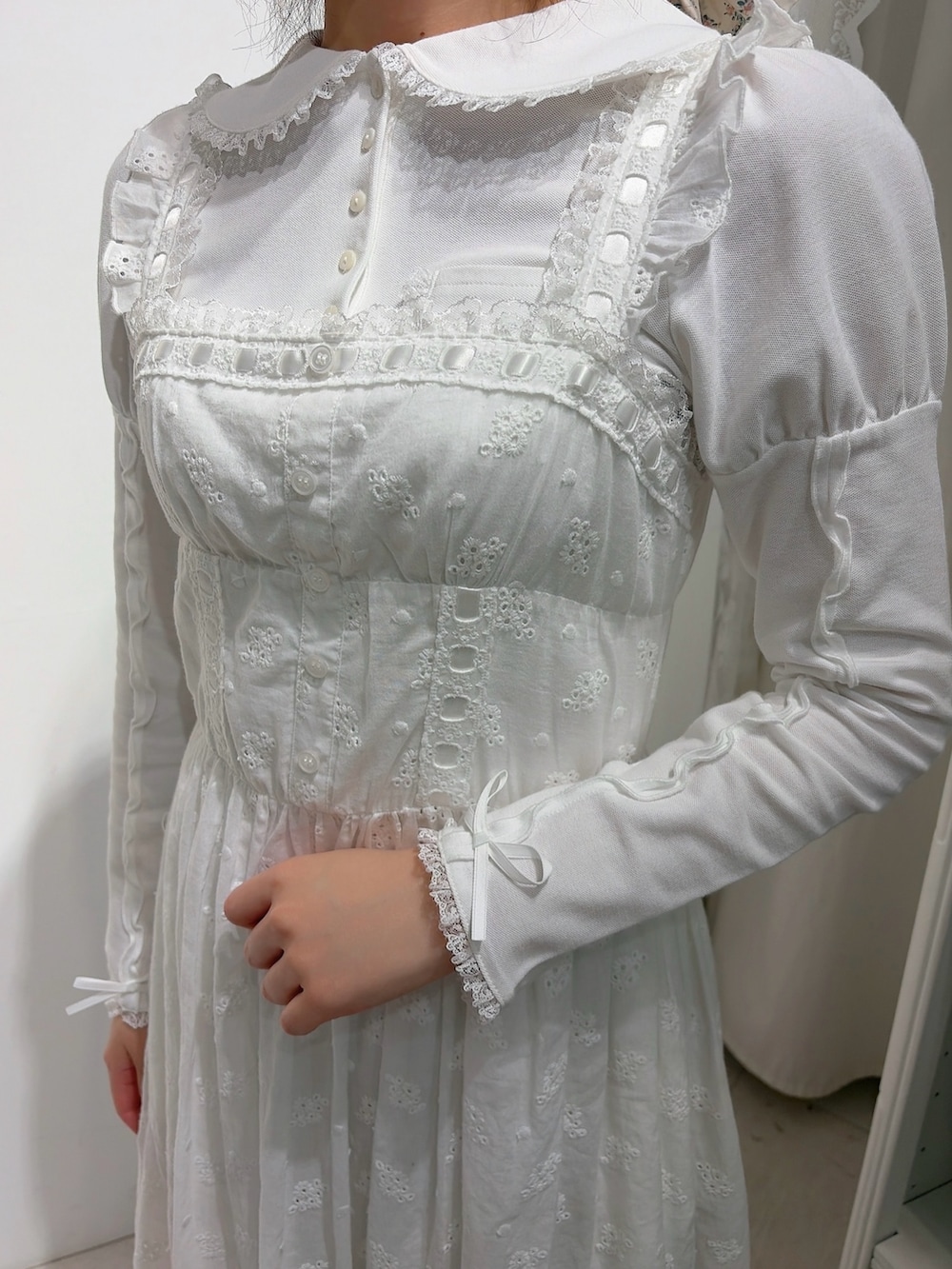 ホワイト系のポロシャツ、ホワイト系のワンピース、ホワイト系のショルダーバッグを着用したレディースの冬コーディネートの6枚目の写真