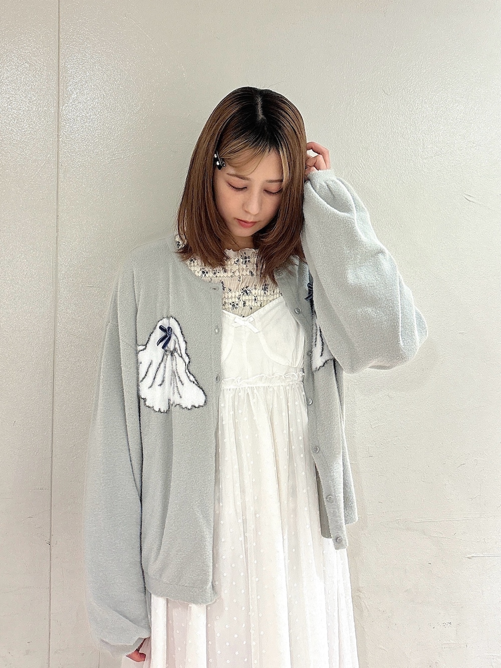 ホワイト系のワンピース、グレー系のカーディガン/ボレロ、ホワイト系のTシャツ/カットソーを着用したレディースの秋コーディネートの3枚目の写真