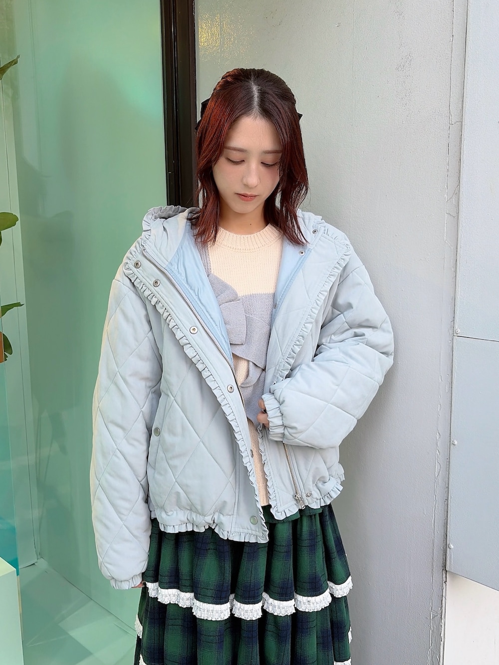 ブルー系のダウンジャケット/コート、ホワイト系のニット/セーター、グリーン系のスカートを着用したレディースの冬コーディネートの3枚目の写真