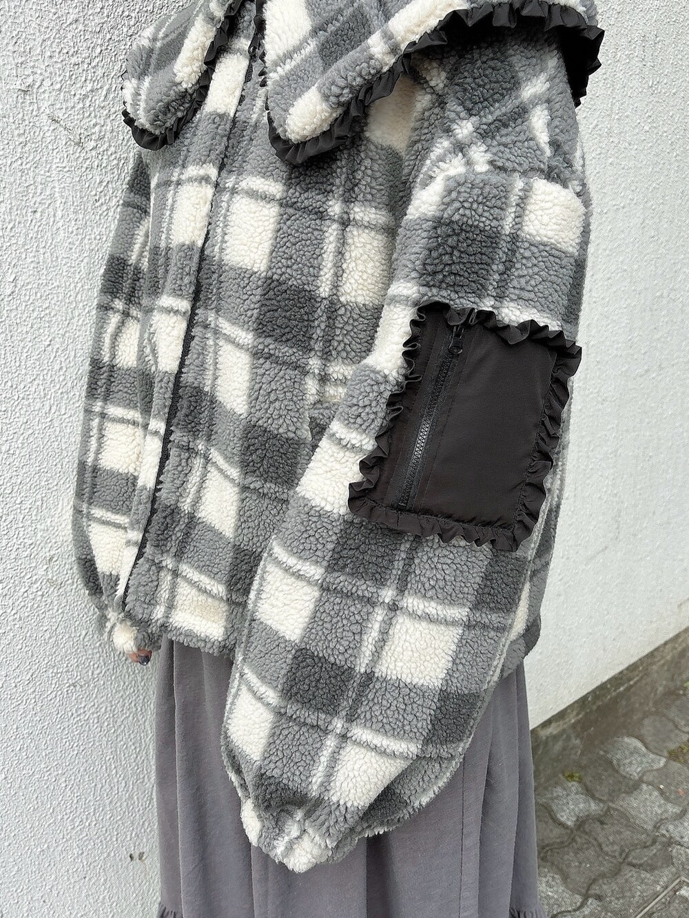 ブラック系のブルゾン、グレー系のワンピース、ホワイト系のブーツを着用したレディースの冬コーディネートの3枚目の写真