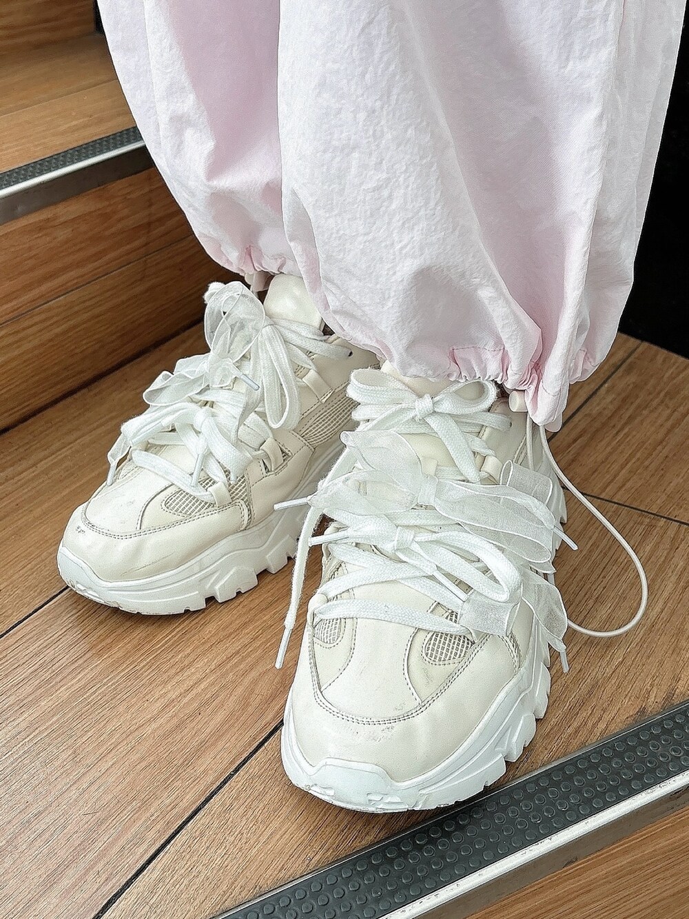 ピンク系のカーゴパンツ、ホワイト系のスニーカー、ホワイト系のTシャツ/カットソーを着用したレディースの冬コーディネートの5枚目の写真