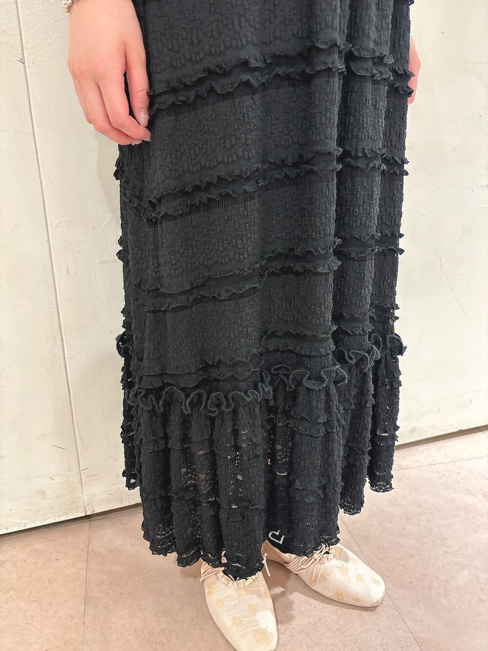 ブラック系のスカート、ブラック系のTシャツ/カットソー、ゴールド系のバレエシューズを着用したレディースの春コーディネートの6枚目の写真