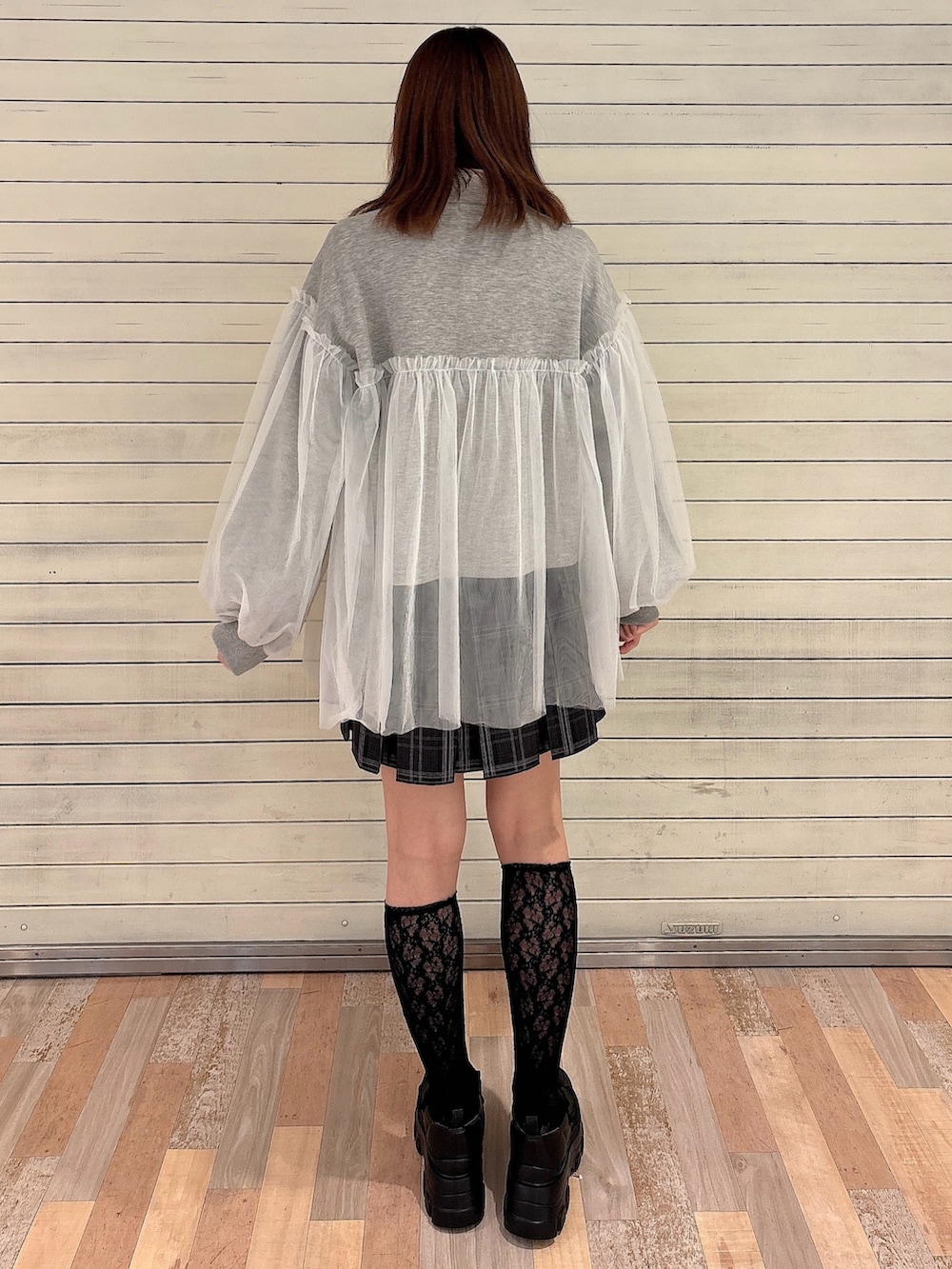 グレー系のスウェット、ブラック系のスカート、ブラック系のローファーを着用したレディースの秋コーディネートの2枚目の写真