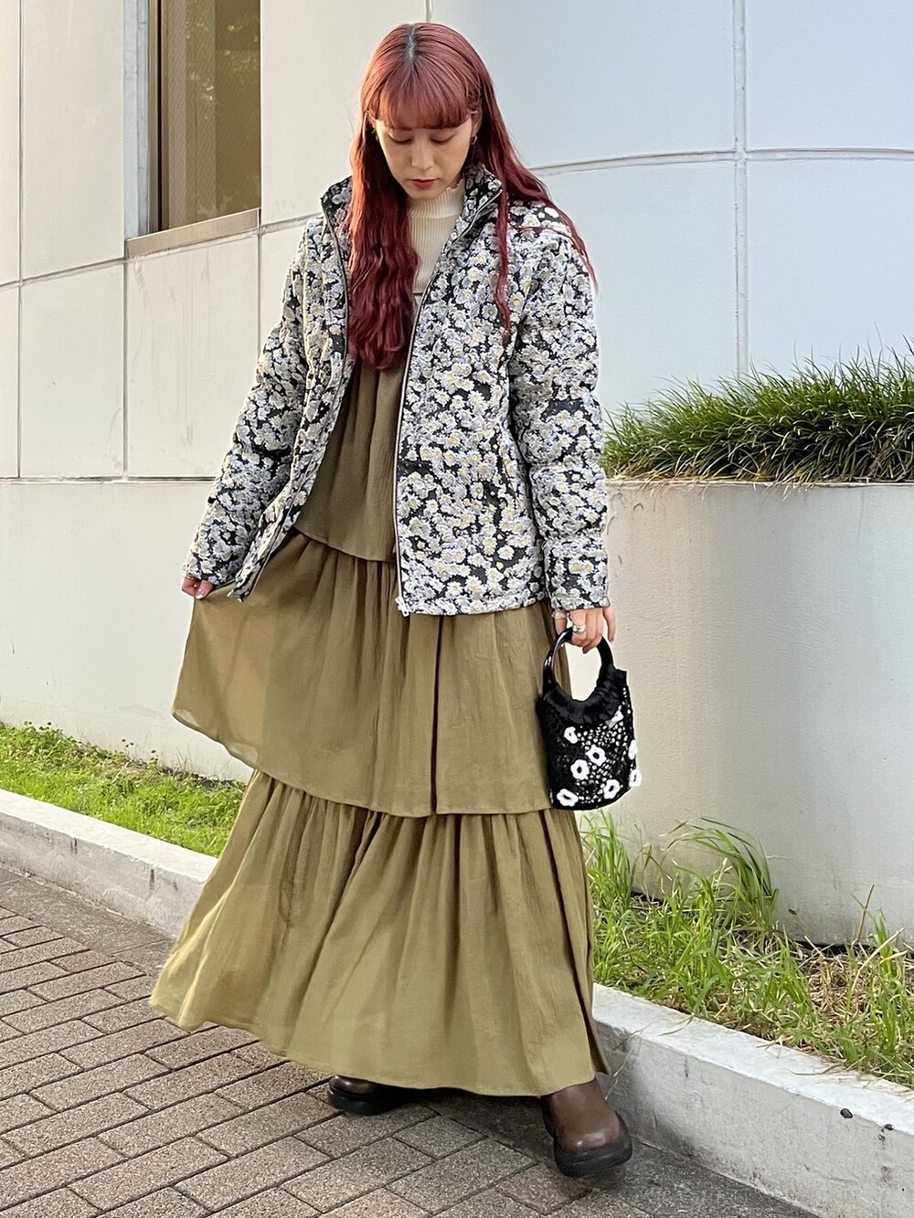 ブラック系のハンドバッグ、ホワイト系のニット/セーター、ブラウン系のブーツを着用したレディースの夏コーディネートの2枚目の写真