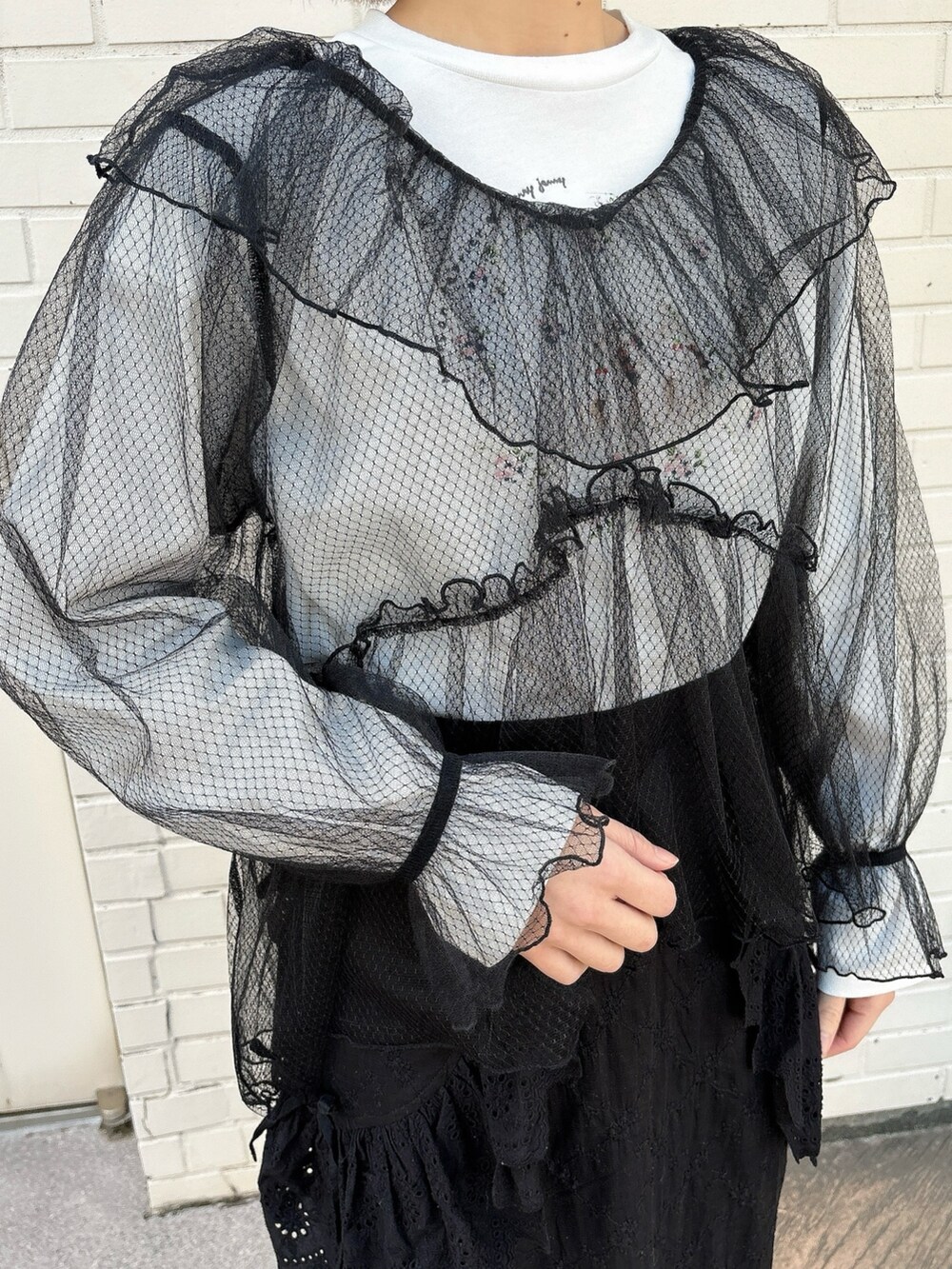 ブラック系のスカート、ブラック系のスニーカー、ホワイト系のTシャツ/カットソーを着用したレディースの春コーディネートの5枚目の写真