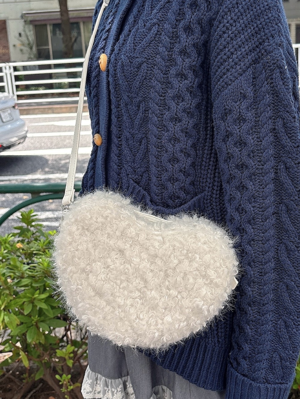 グレー系のスカート、ブルー系のカーディガン/ボレロ、ホワイト系のショルダーバッグを着用したレディースの夏コーディネートの5枚目の写真