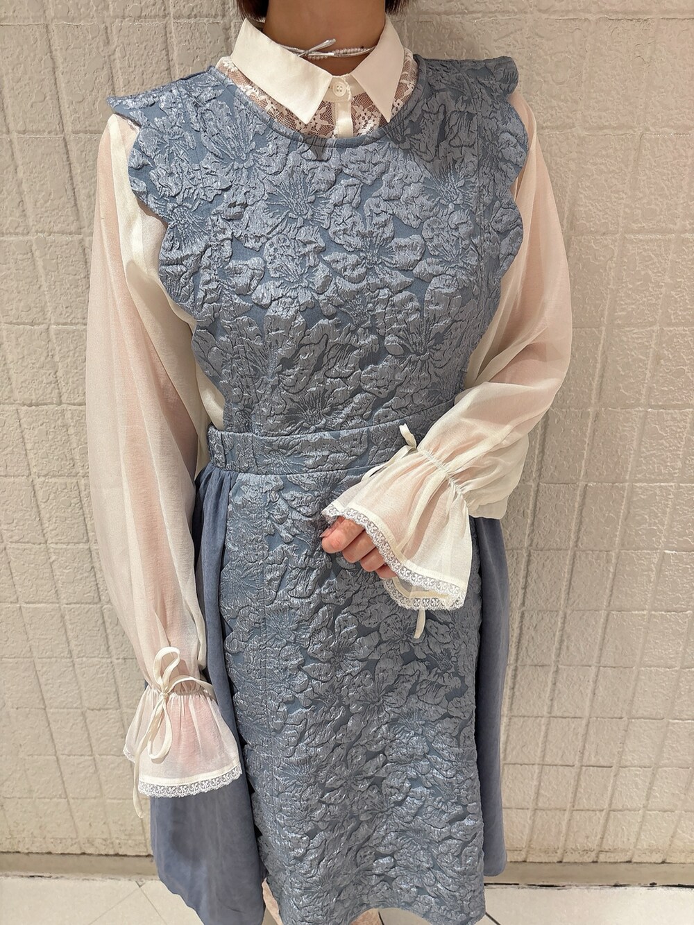 ブルー系のワンピース、ホワイト系のシャツ/ブラウス、ブラック系のスニーカーを着用したレディースの春コーディネートの5枚目の写真