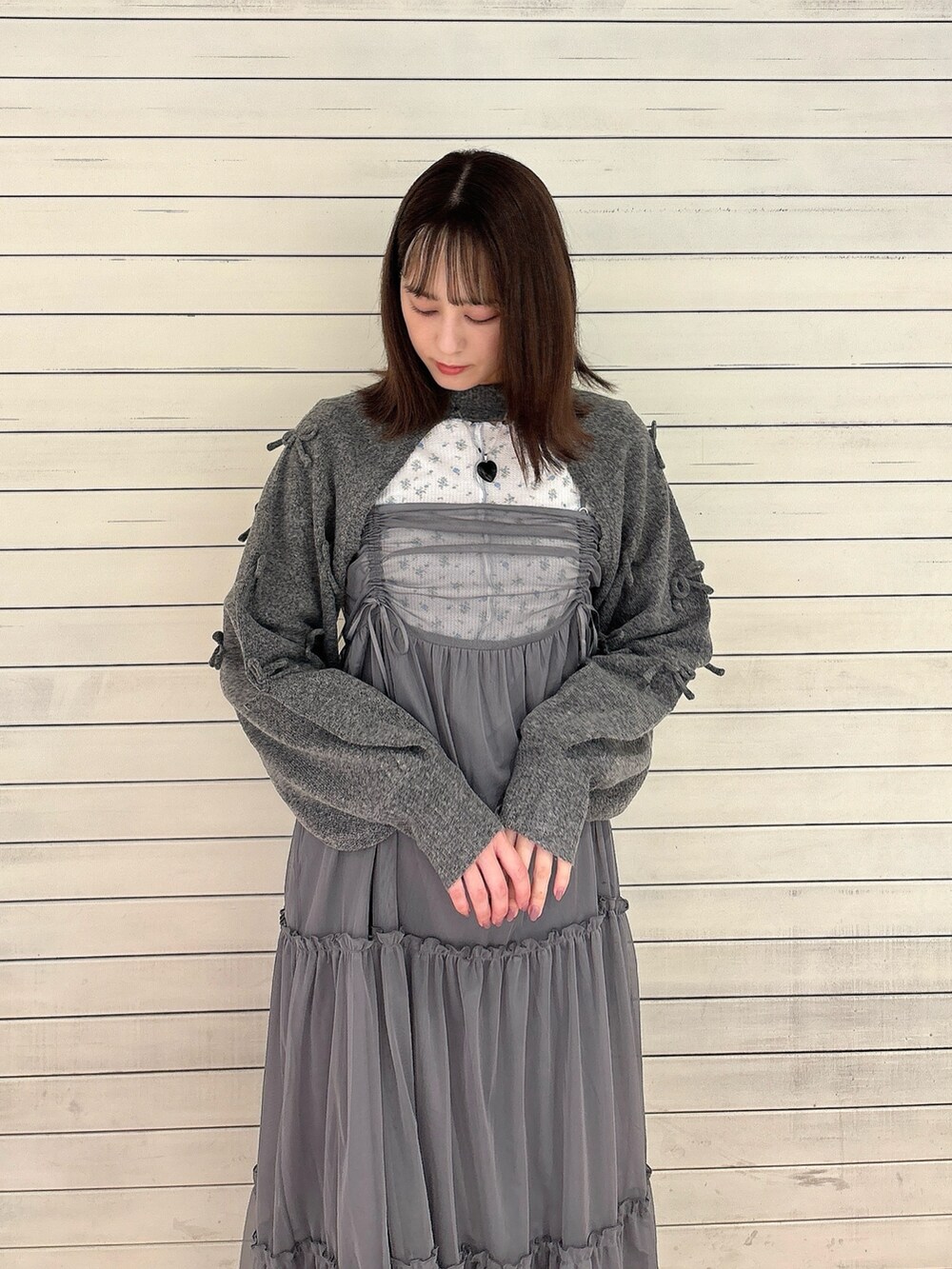 グレー系のワンピース、ブラック系のバレエシューズ、グレー系のカーディガン/ボレロを着用したレディースの秋コーディネートの3枚目の写真