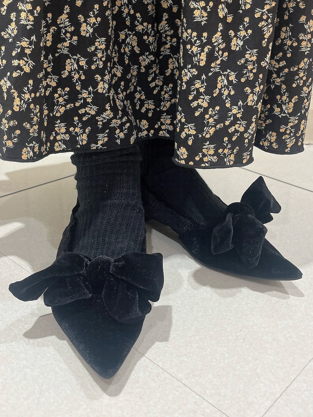 ブルー系のカーディガン/ボレロ、ブラック系のスカート、ブラック系のパンプスを着用したレディースの秋コーディネートの3枚目の写真