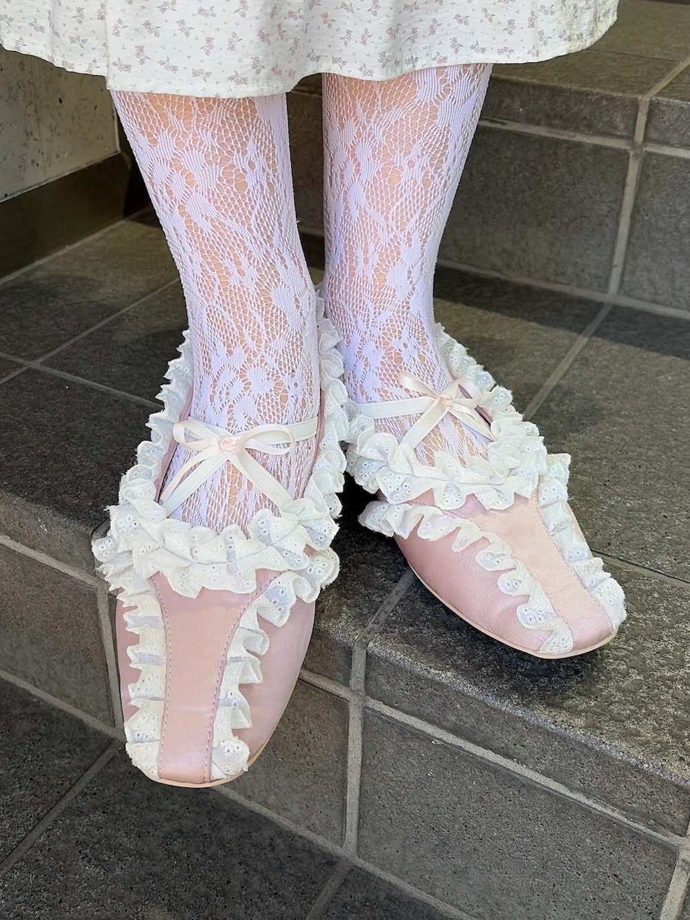 ホワイト系のワンピース、ピンク系のバレエシューズ、ピンク系のベストを着用したレディースの冬コーディネートの7枚目の写真