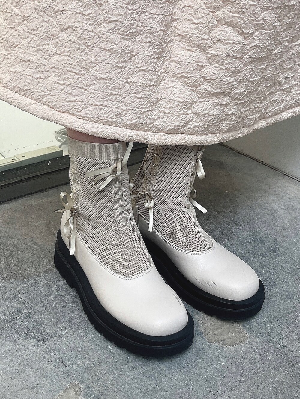 ホワイト系のワンピース、ブルー系のニット/セーター、ホワイト系のブーツを着用したレディースの秋コーディネートの3枚目の写真