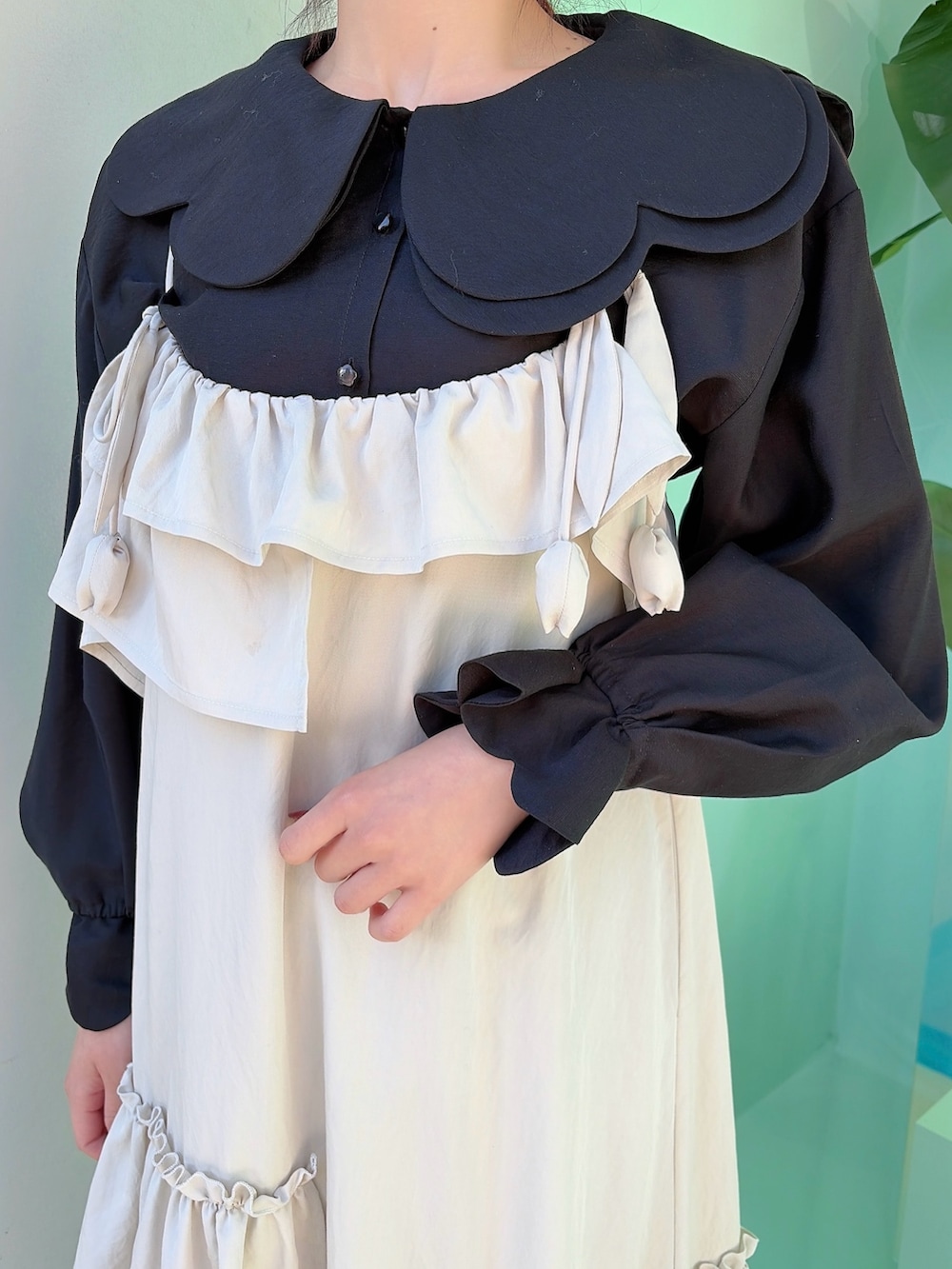 ベージュ系のワンピース、ブラック系のシャツ/ブラウス、ホワイト系のスニーカーを着用したレディースの冬コーディネートの5枚目の写真