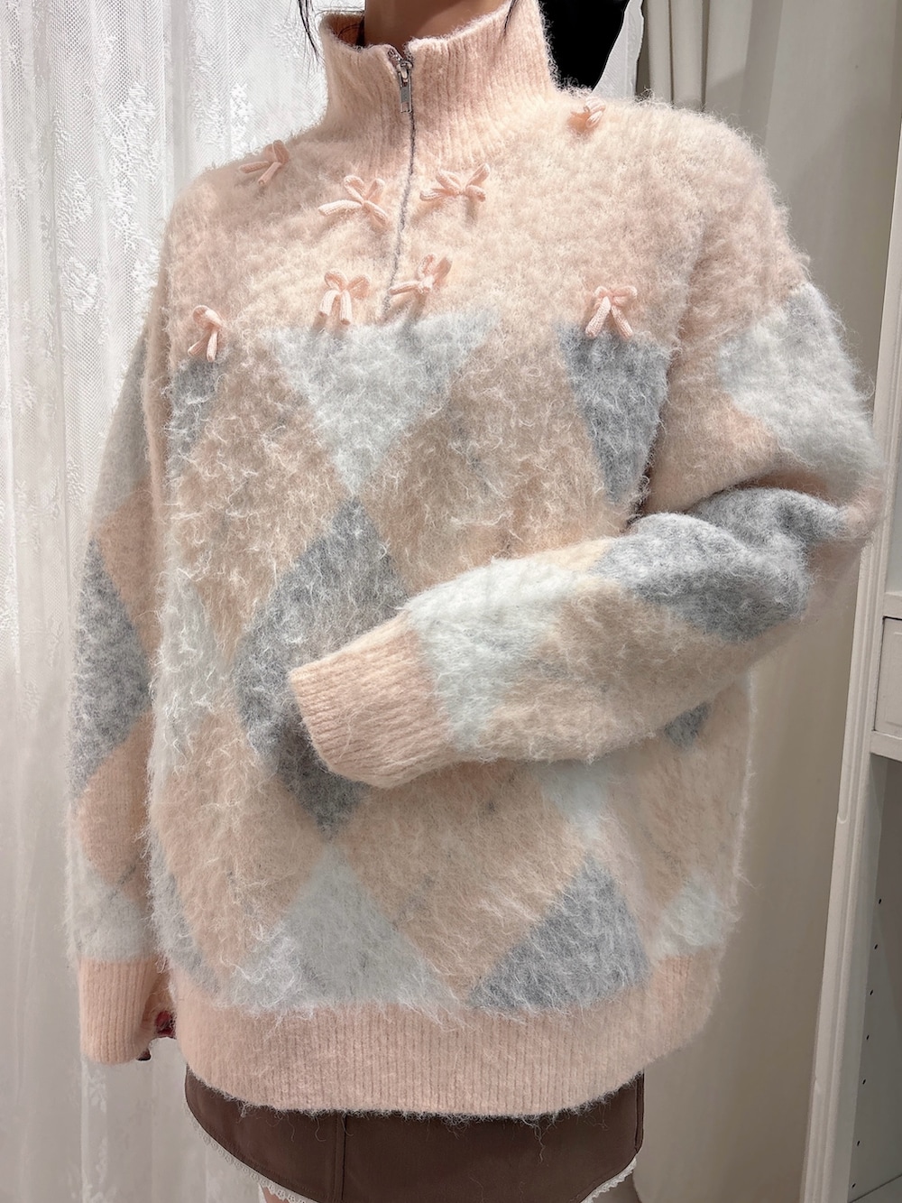 ピンク系のニット/セーター、ブラウン系のスカート、ピンク系のブーツを着用したレディースの秋コーディネートの5枚目の写真