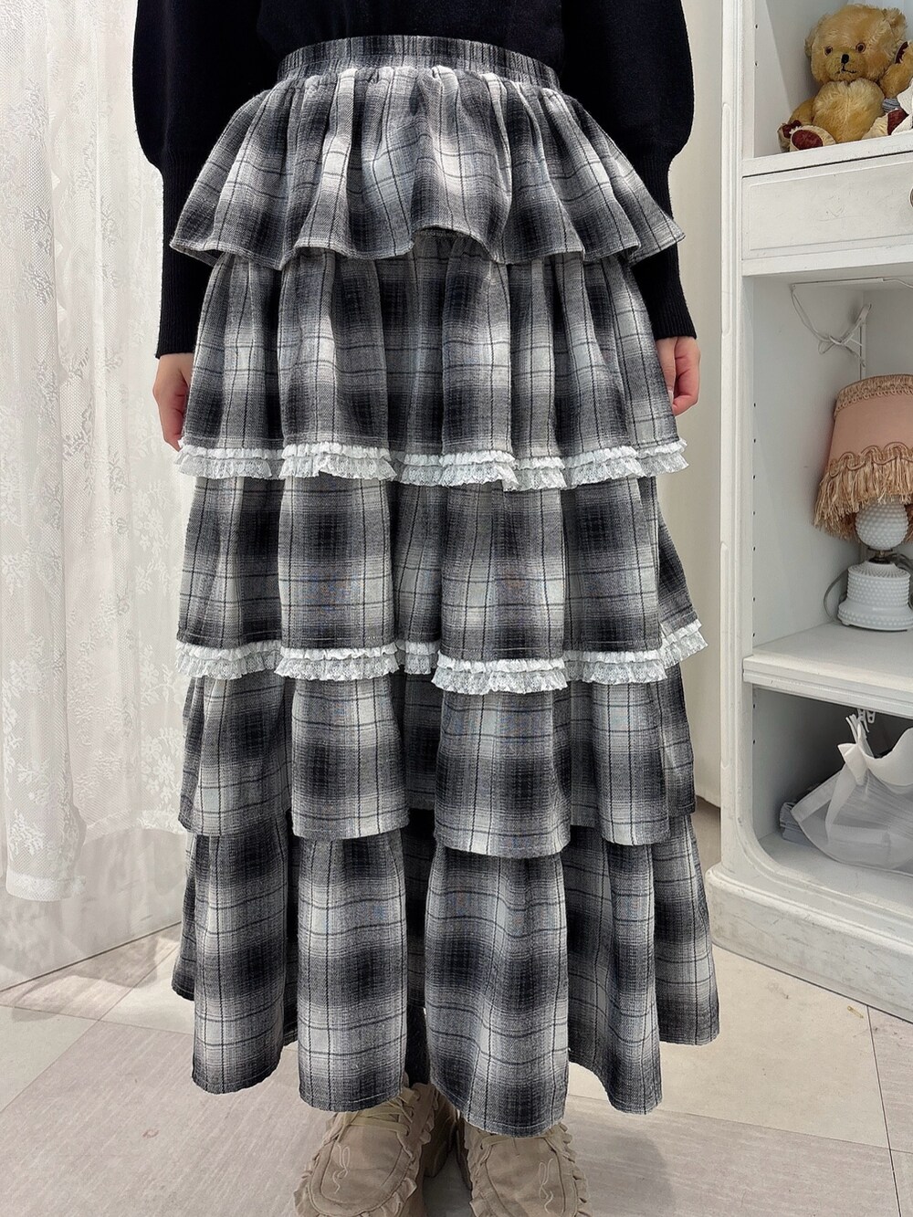 ブラック系のニット/セーター、ブラック系のスカート、グレー系のショルダーバッグを着用したレディースの秋コーディネートの7枚目の写真