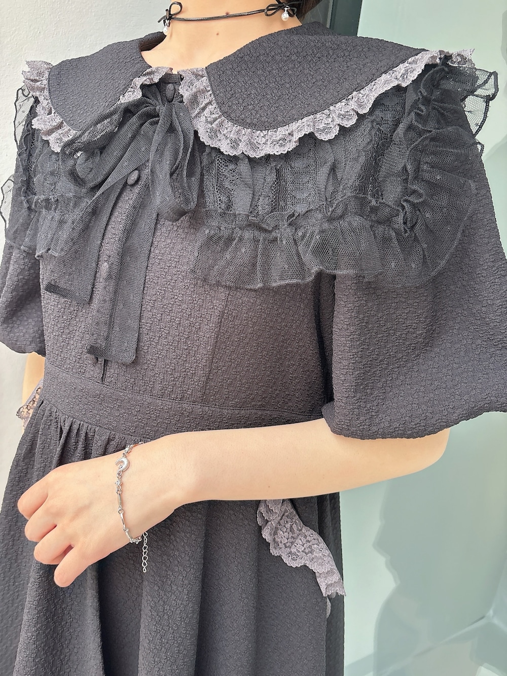 ブラック系のワンピース、ブラック系のスニーカー、ブラック系の付け襟を着用したレディースの春コーディネートの5枚目の写真