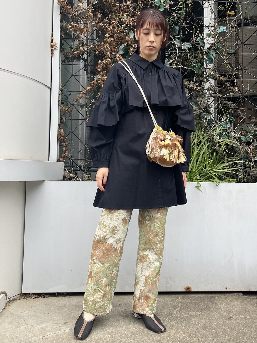 ブラウン系のハンドバッグ、ブラック系のワンピース、イエロー系のその他パンツを着用したレディースの冬コーディネートの2枚目の写真