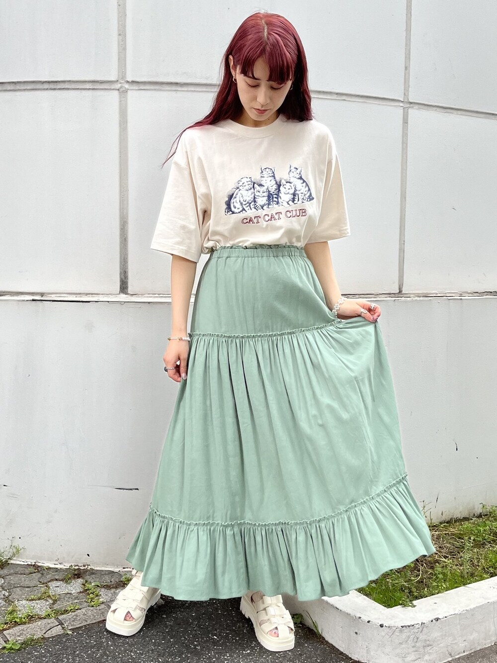 ホワイト系のトートバッグ、レッド系のサンダル、グリーン系のスカートを着用したレディースの春コーディネートの2枚目の写真