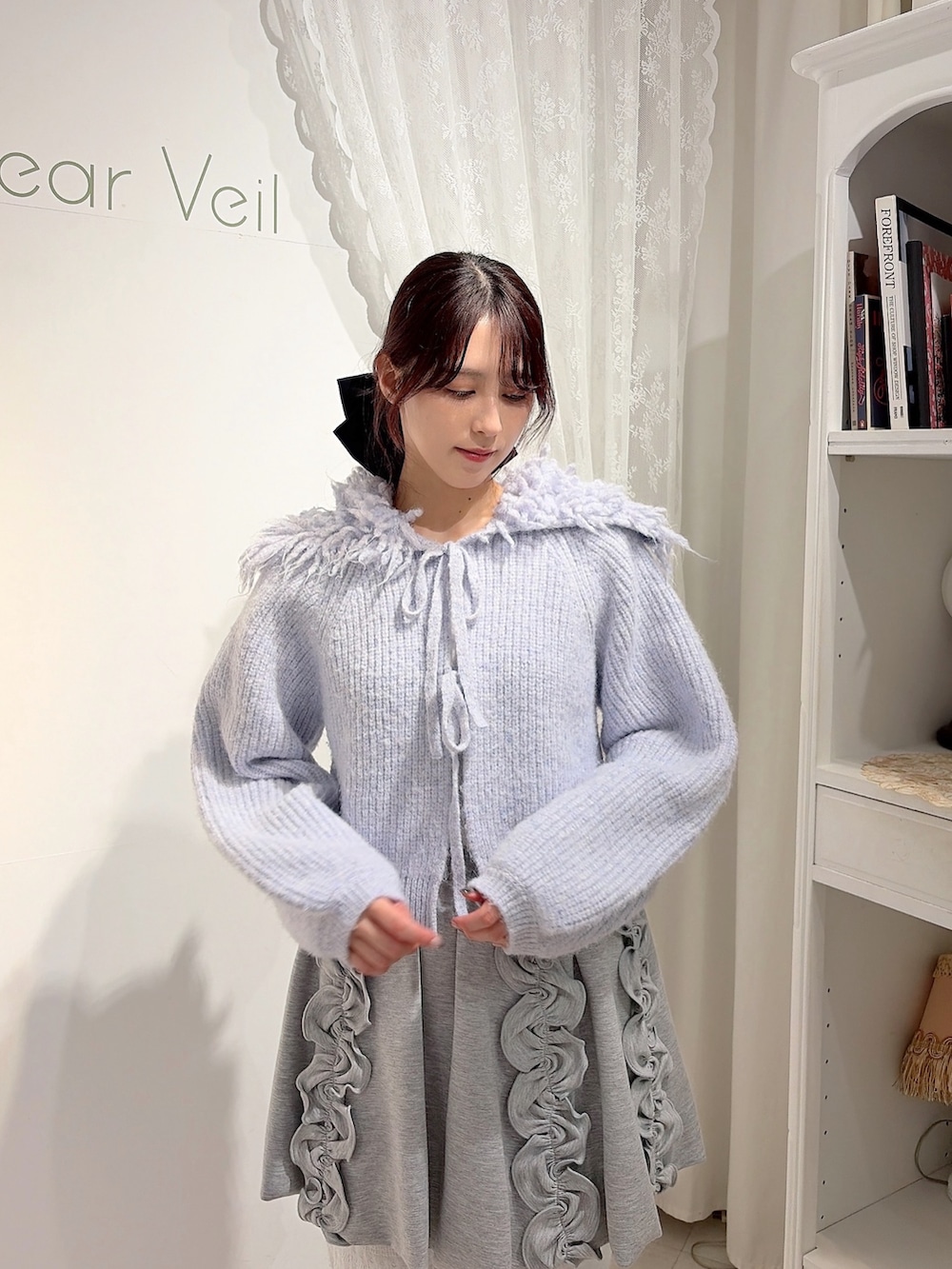 ブルー系のカーディガン/ボレロ、ホワイト系のショルダーバッグ、グレー系のスカートを着用したレディースの秋コーディネートの4枚目の写真