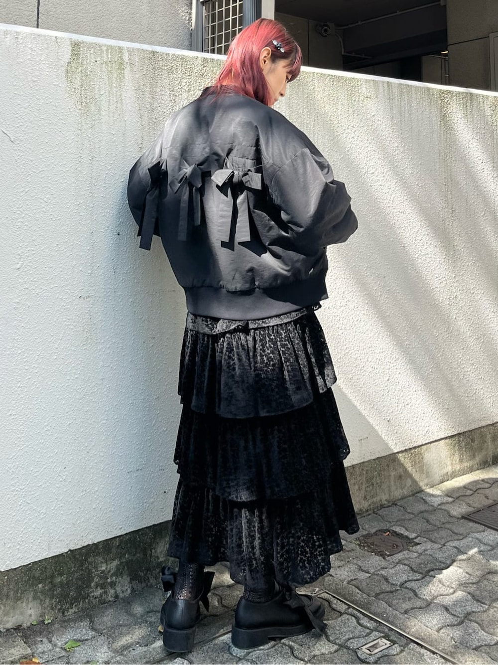 ブラック系のニット/セーター、ブラック系のスカート、ブラック系のモカシン/デッキシューズを着用したレディースの秋コーディネートの2枚目の写真