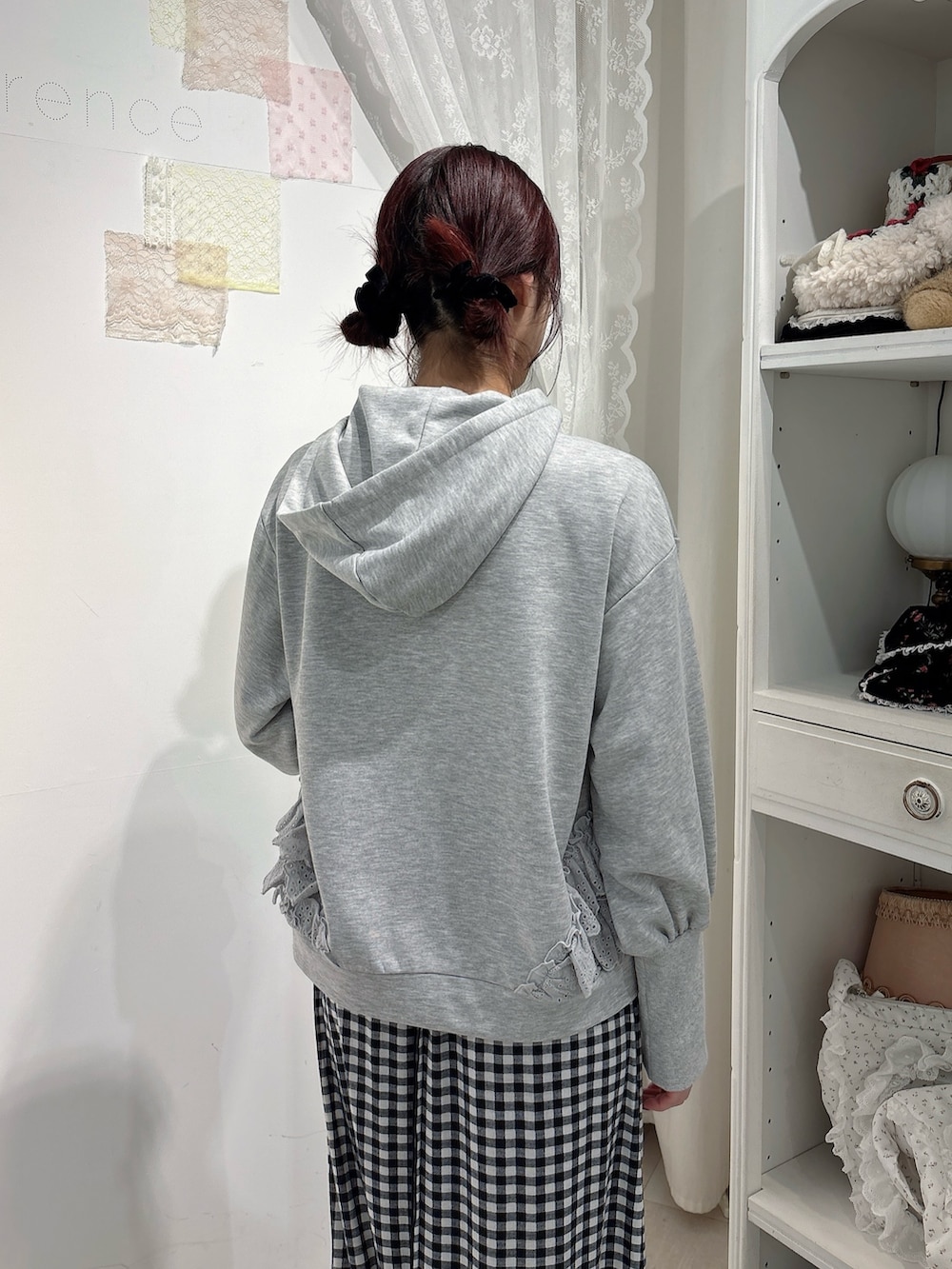 グレー系のパーカー、ブラック系のスカート、ホワイト系のスニーカーを着用したレディースの秋コーディネートの4枚目の写真