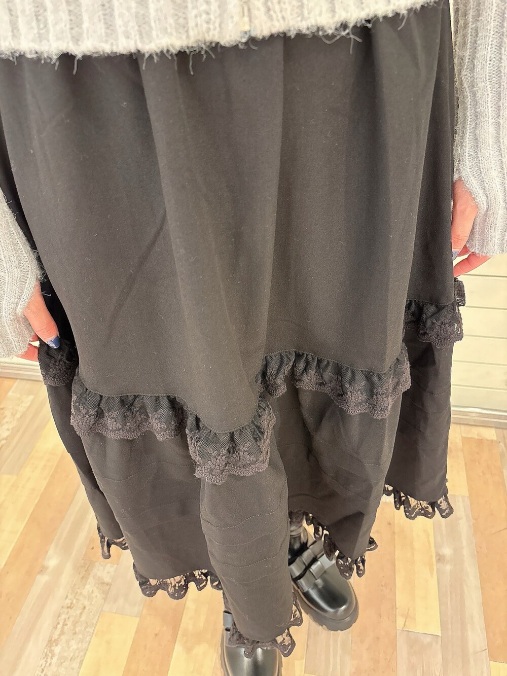 グレー系のカーディガン/ボレロ、ブラック系のスカート、ブラック系のブーツを着用したレディースの冬コーディネートの7枚目の写真