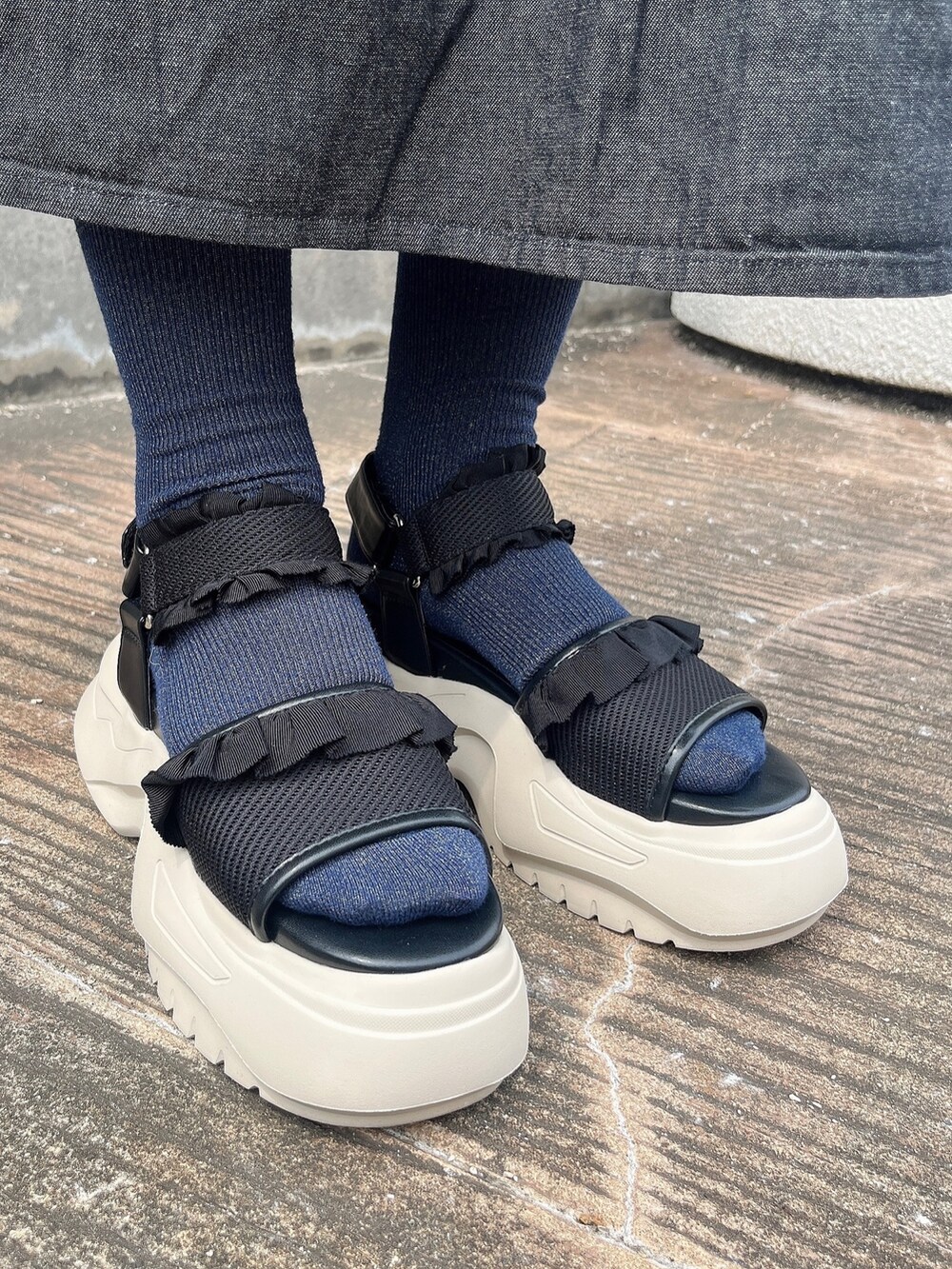 ブラック系のワンピース、ブラック系のサンダル、ブルー系のシャツ/ブラウスを着用したレディースの夏コーディネートの3枚目の写真