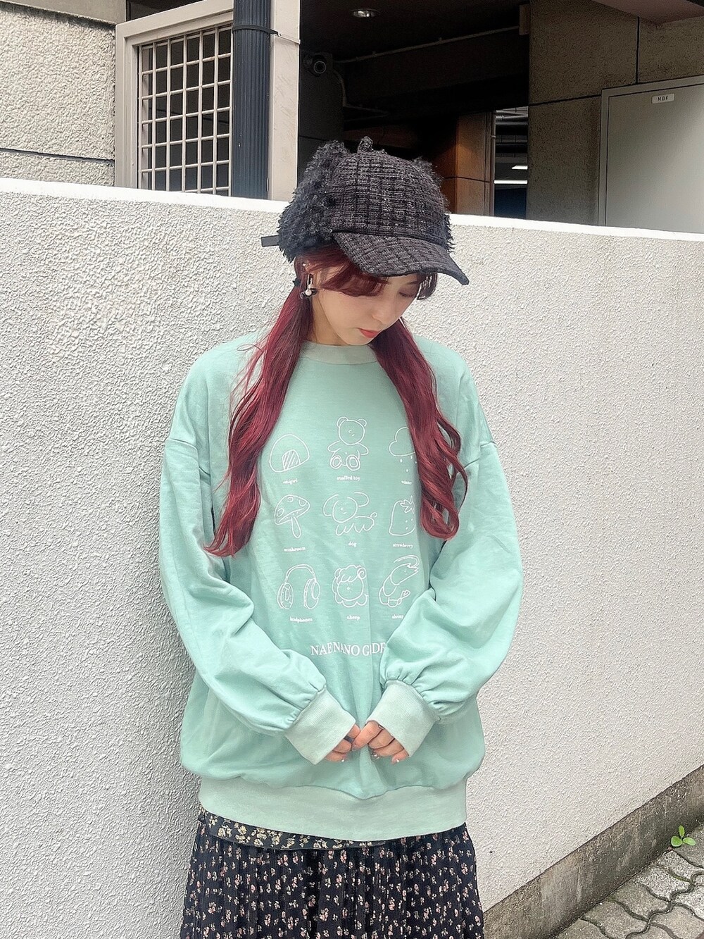 グリーン系のスウェット、ブラック系のスカート、ブラック系のブーツを着用したレディースの秋コーディネートの2枚目の写真