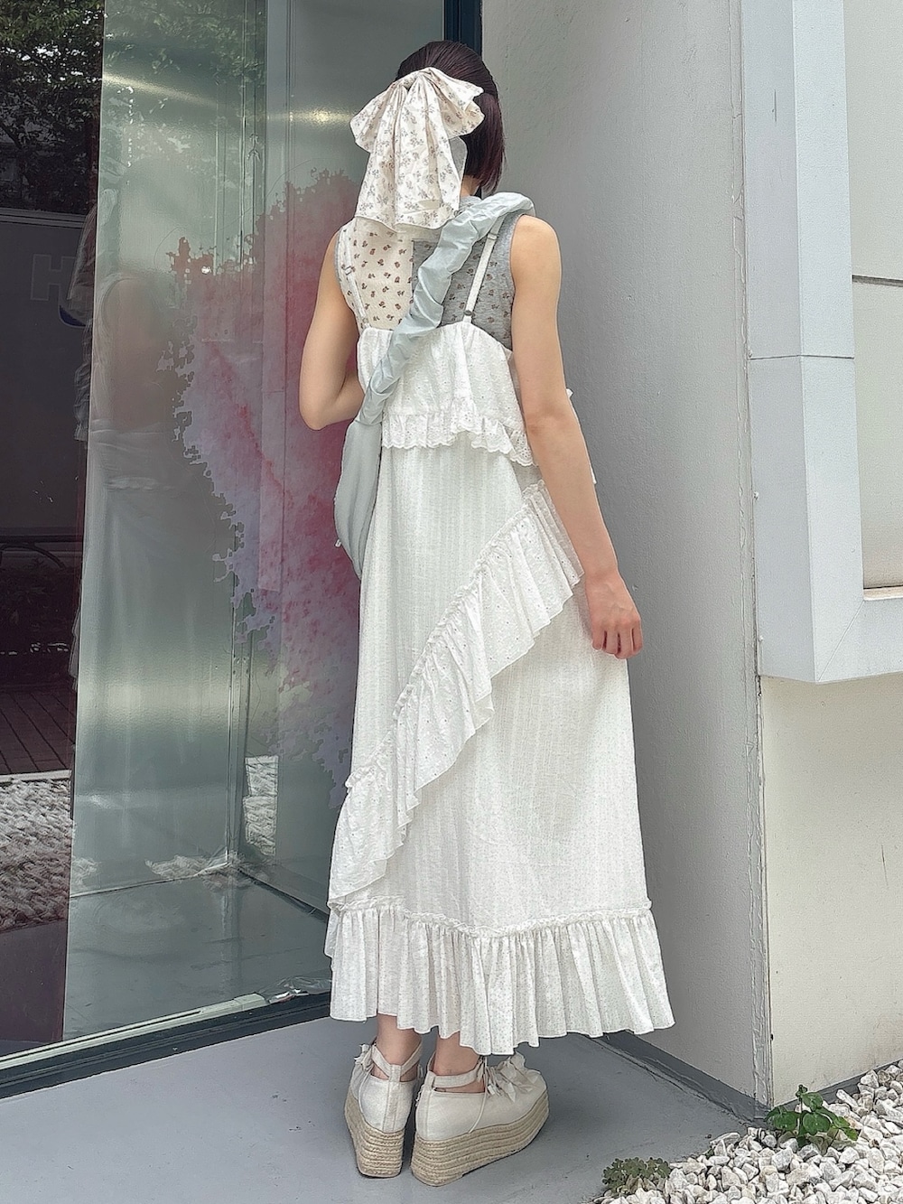 ブルー系のショルダーバッグ、ホワイト系のワンピース、ホワイト系のサンダルを着用したレディースの夏コーディネートの2枚目の写真