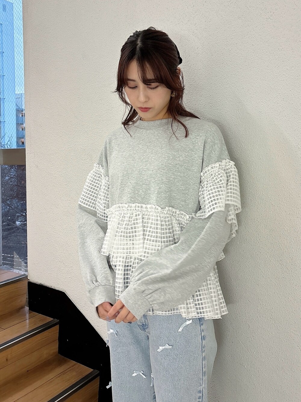 ブルー系のデニムパンツ、ホワイト系のスニーカー、グレー系のスウェットを着用したレディースの冬コーディネートの2枚目の写真