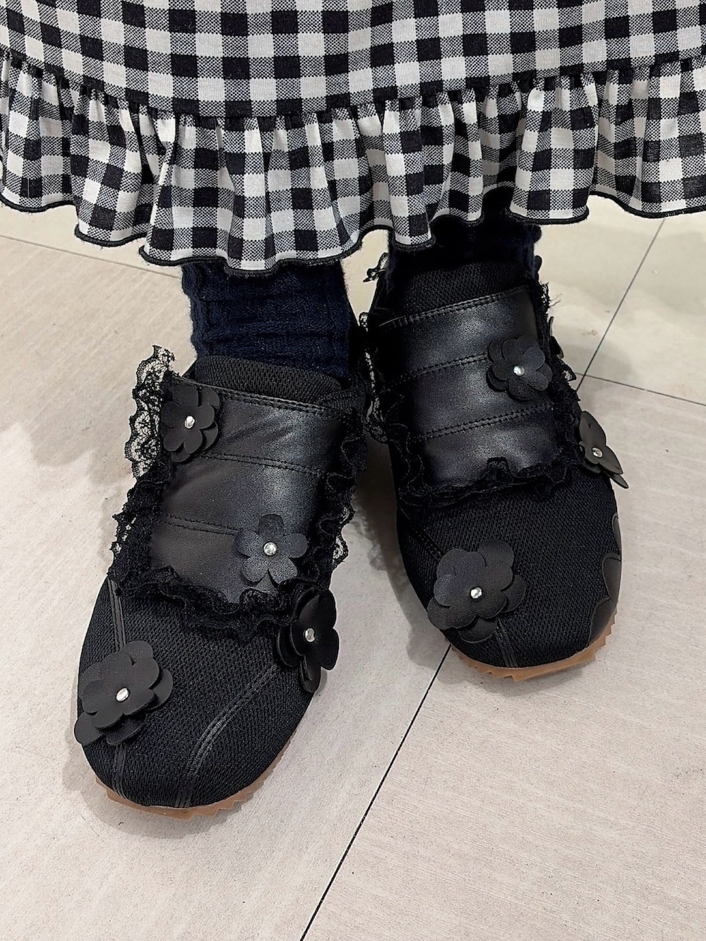 ホワイト系のカーディガン/ボレロ、ブラック系のスカート、ブラック系のスニーカーを着用したレディースの冬コーディネートの7枚目の写真