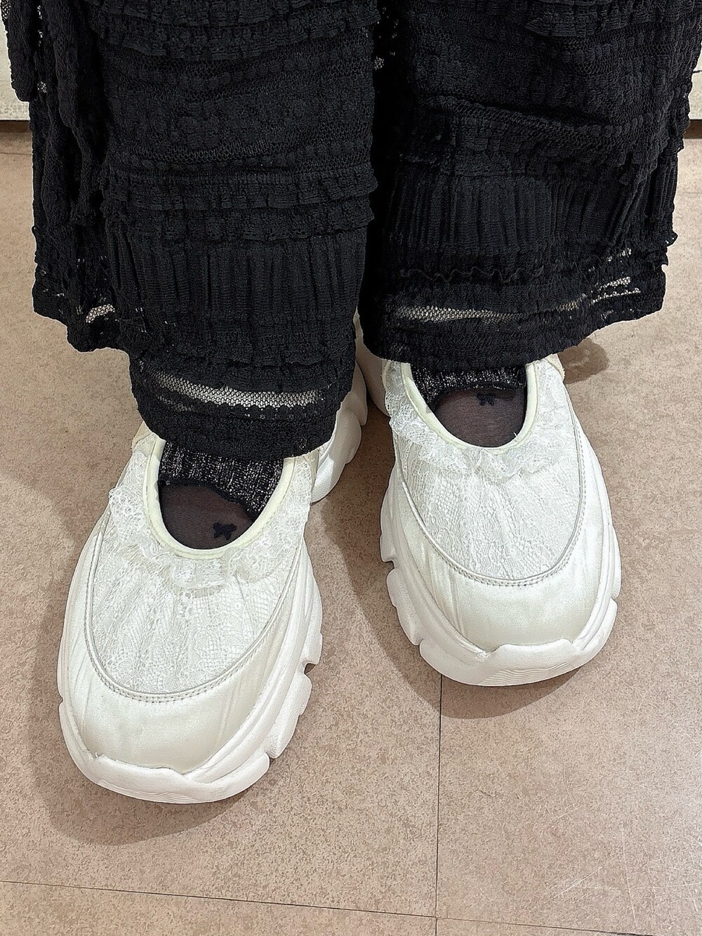 グレー系のスウェット、ブラック系のその他パンツ、ホワイト系のスニーカーを着用したレディースの冬コーディネートの6枚目の写真