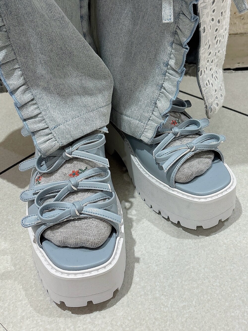 ピンク系のワンピース、ブルー系のデニムパンツ、ブルー系のサンダルを着用したレディースの夏コーディネートの7枚目の写真