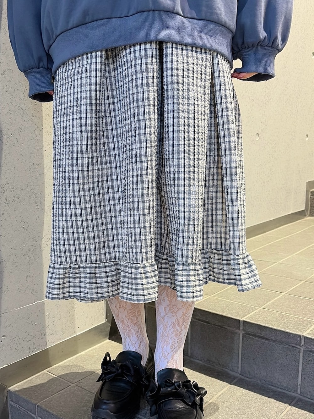 ブルー系のスウェット、ブルー系のワンピース、ブラック系のスニーカーを着用したレディースの冬コーディネートの6枚目の写真