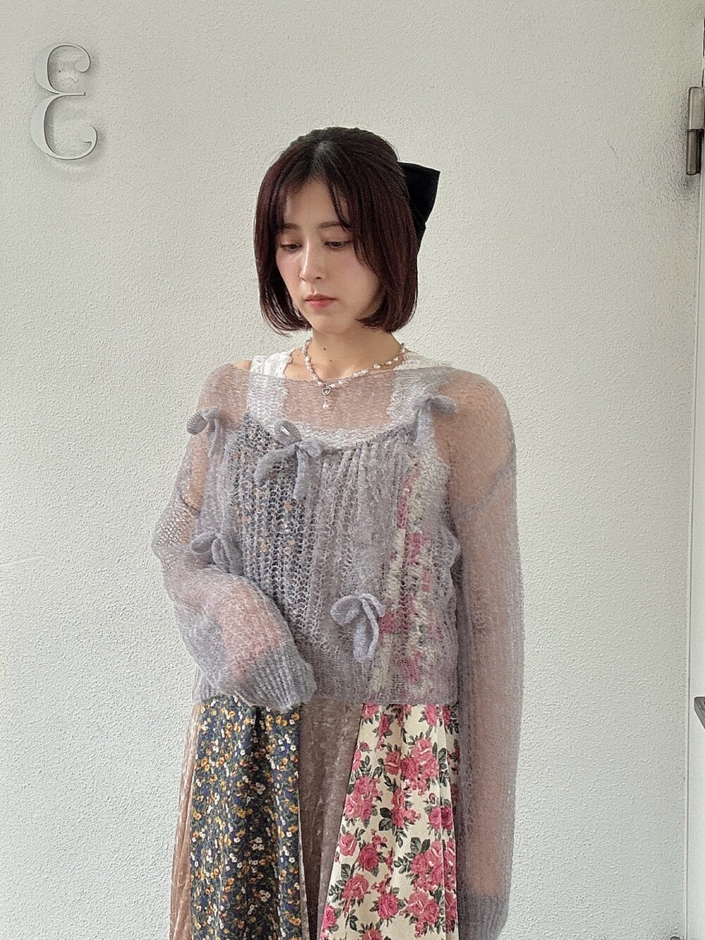 グレー系のニット/セーター、ピンク系のワンピース、ブラウン系のブーツを着用したレディースの夏コーディネートの3枚目の写真