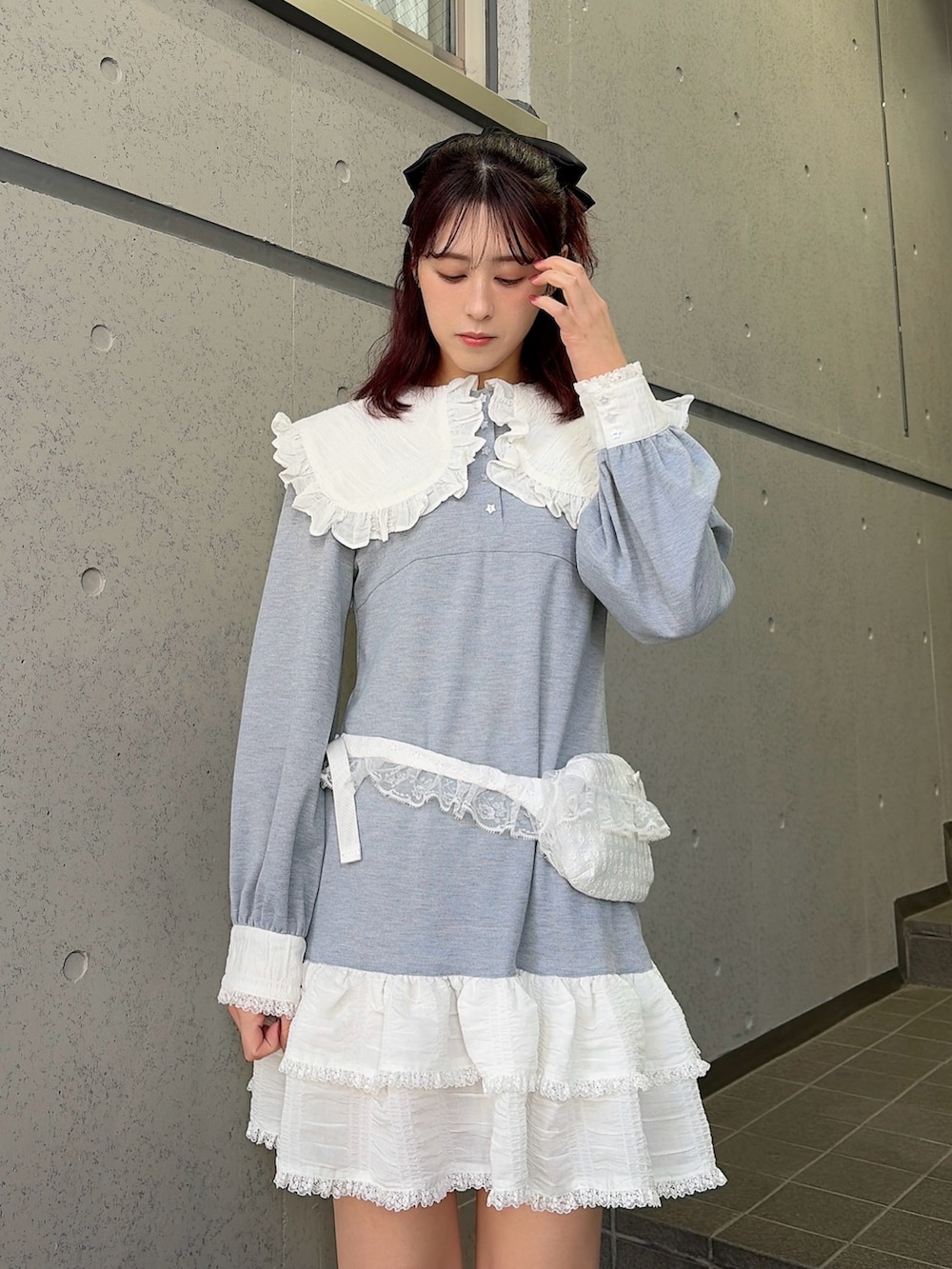 グレー系のワンピース、ブラック系のスニーカー、ホワイト系のボディバッグ/ウエストポーチを着用したレディースの冬コーディネートの3枚目の写真