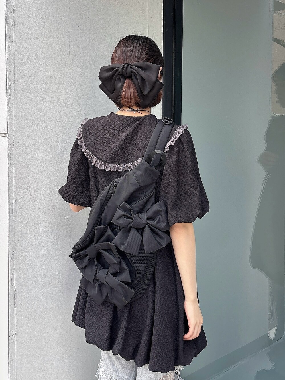 グレー系のスウェットパンツ、ブラック系のスニーカー、ブラック系のワンピースを着用したレディースの春コーディネートの4枚目の写真