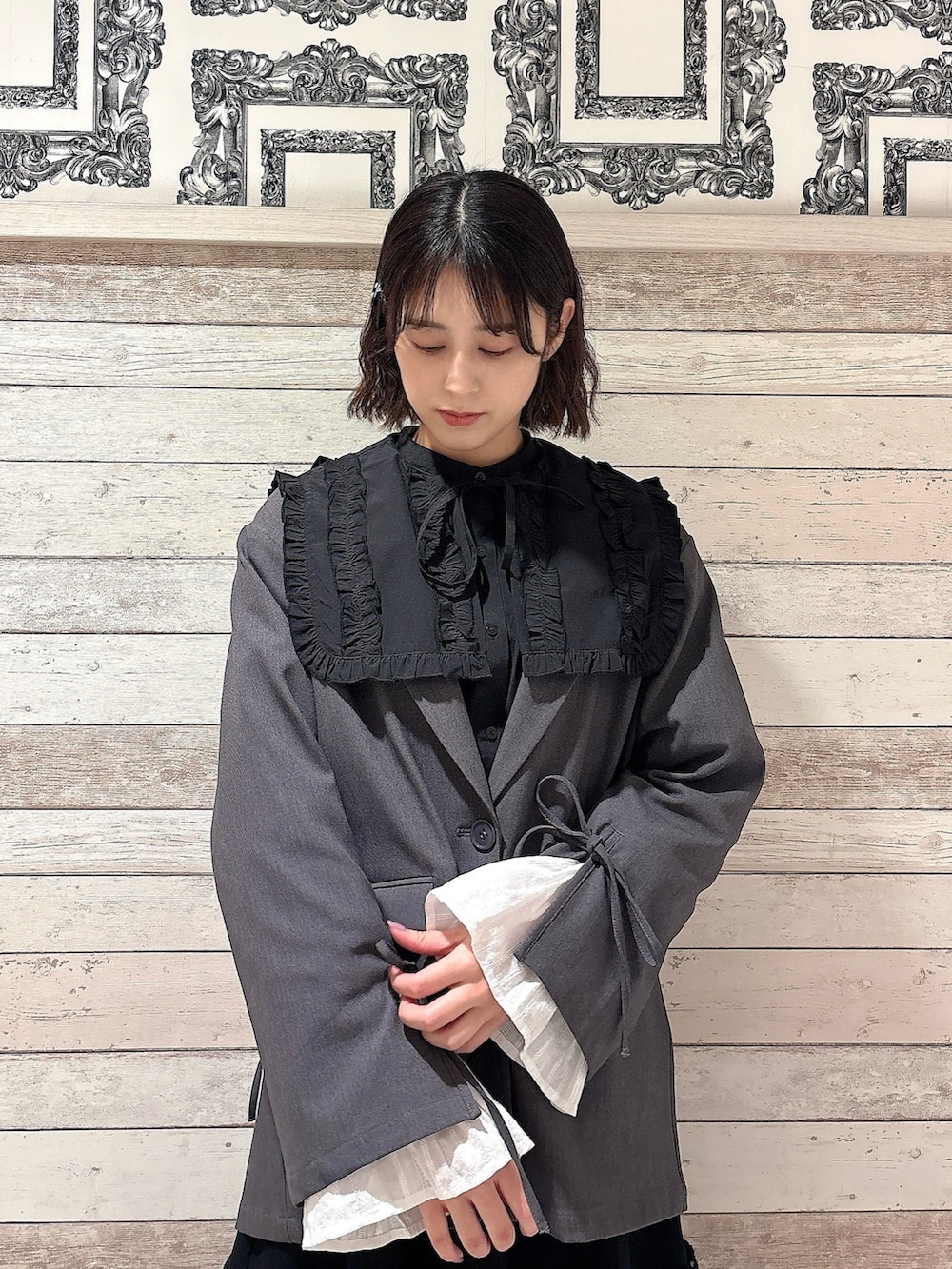 ブラック系のシャツ/ブラウス、グレー系のテーラードジャケット、ブラック系のスカートを着用したレディースの冬コーディネートの3枚目の写真