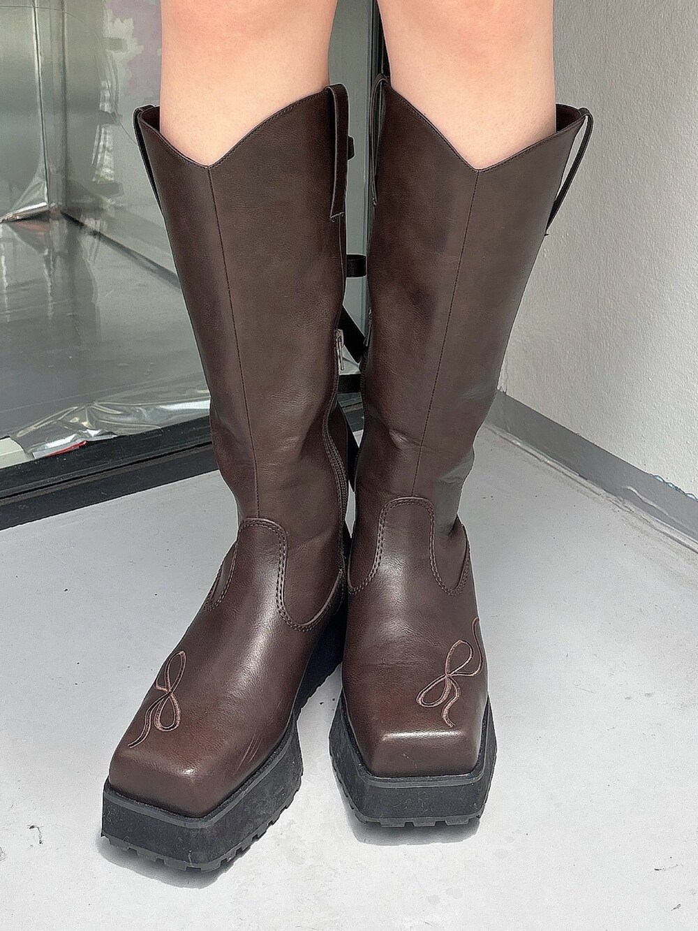 ブラウン系のワンピース、ブラウン系のブーツ、ブラック系のレギンス/スパッツを着用したレディースの夏コーディネートの6枚目の写真