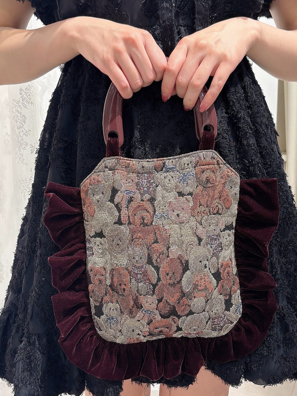 ブラック系のワンピース、ブラック系のサンダル、レッド系のハンドバッグを着用したレディースの夏コーディネートの6枚目の写真