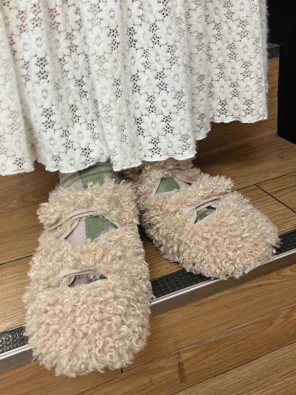 レッド系のカーディガン/ボレロ、ホワイト系のスカート、ベージュ系のスリッポンを着用したレディースの秋コーディネートの3枚目の写真