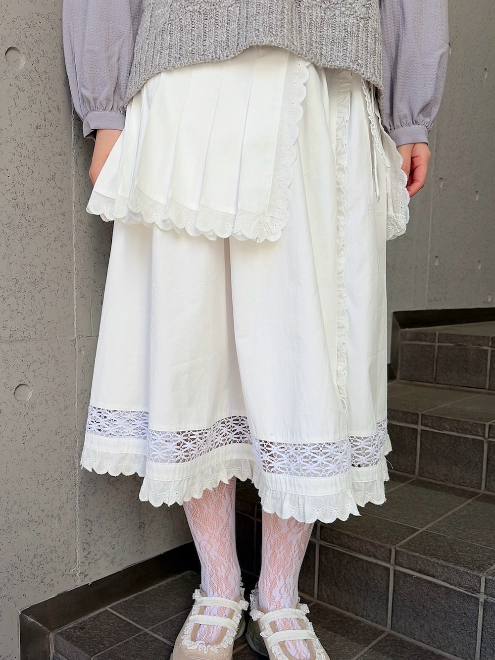 グレー系のシャツ/ブラウス、ホワイト系のスカート、ホワイト系のスニーカーを着用したレディースの冬コーディネートの6枚目の写真