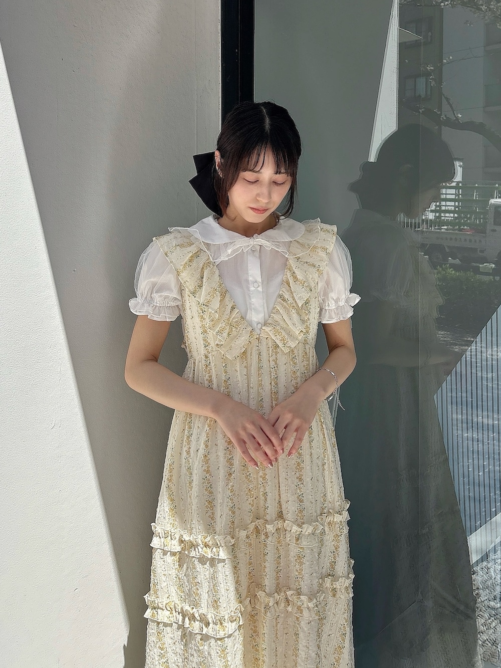 ホワイト系のシャツ/ブラウス、イエロー系のワンピース、ホワイト系のサンダルを着用したレディースの春コーディネートの3枚目の写真