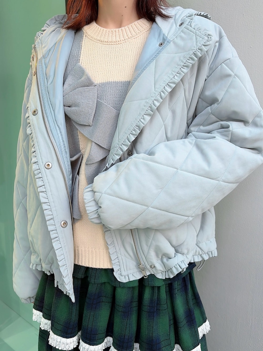 ブルー系のダウンジャケット/コート、ホワイト系のニット/セーター、グリーン系のスカートを着用したレディースの冬コーディネートの5枚目の写真