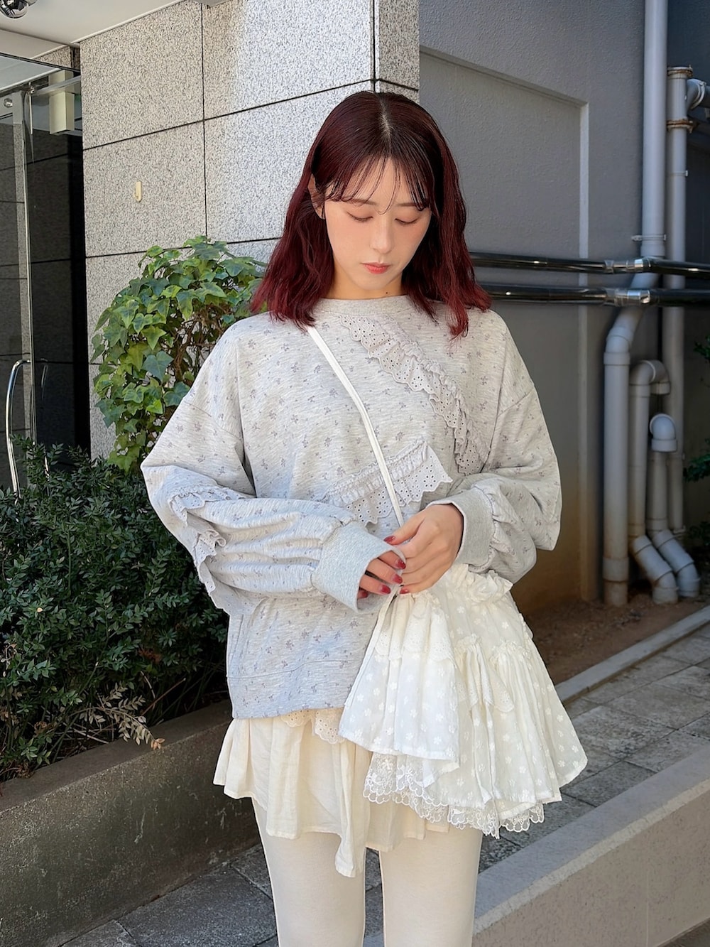 グレー系のスウェット、ホワイト系のショルダーバッグ、ホワイト系のスウェットパンツを着用したレディースの冬コーディネートの3枚目の写真