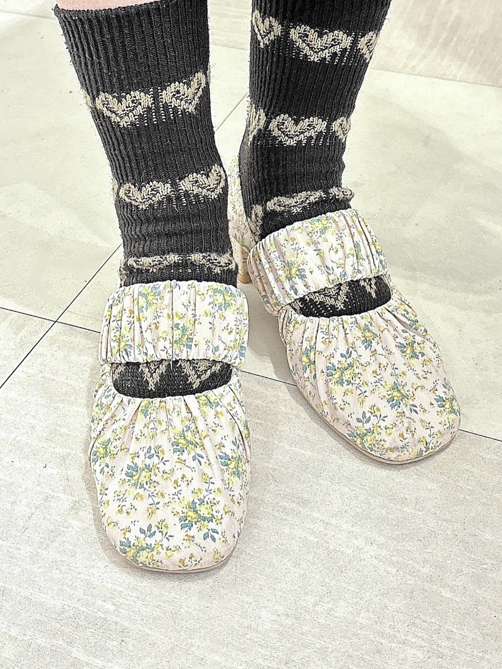 ピンク系のパンプス、ブラック系のワンピース、ブラック系の付け襟を着用したレディースの冬コーディネートの5枚目の写真