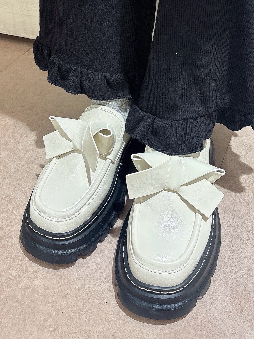 ホワイト系のニット/セーター、ブラック系のスカート、ブラック系のスウェットパンツを着用したレディースの秋コーディネートの7枚目の写真