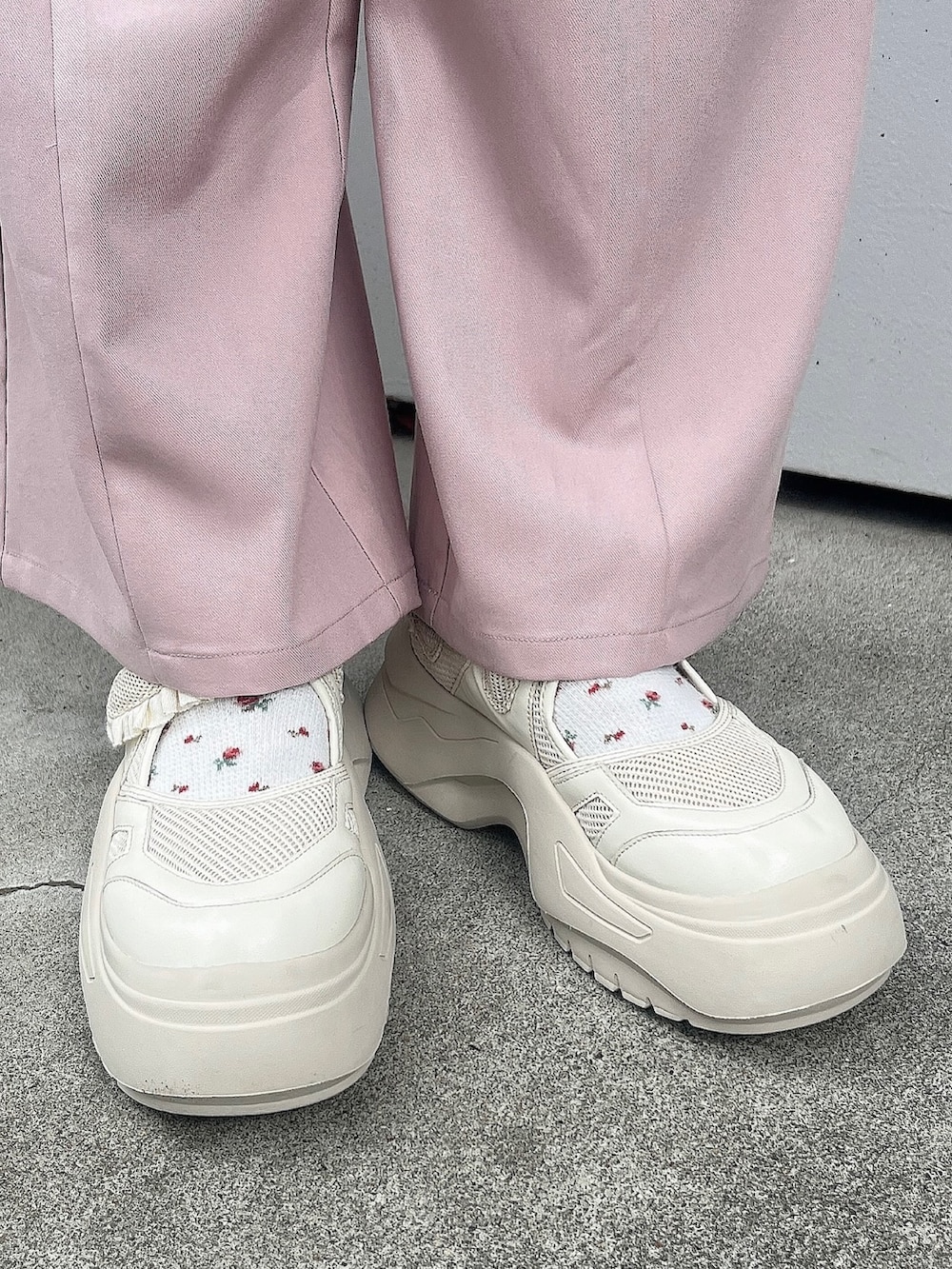ピンク系のスラックス、ピンク系のカーディガン/ボレロ、ホワイト系のハンドバッグを着用したレディースの秋コーディネートの4枚目の写真